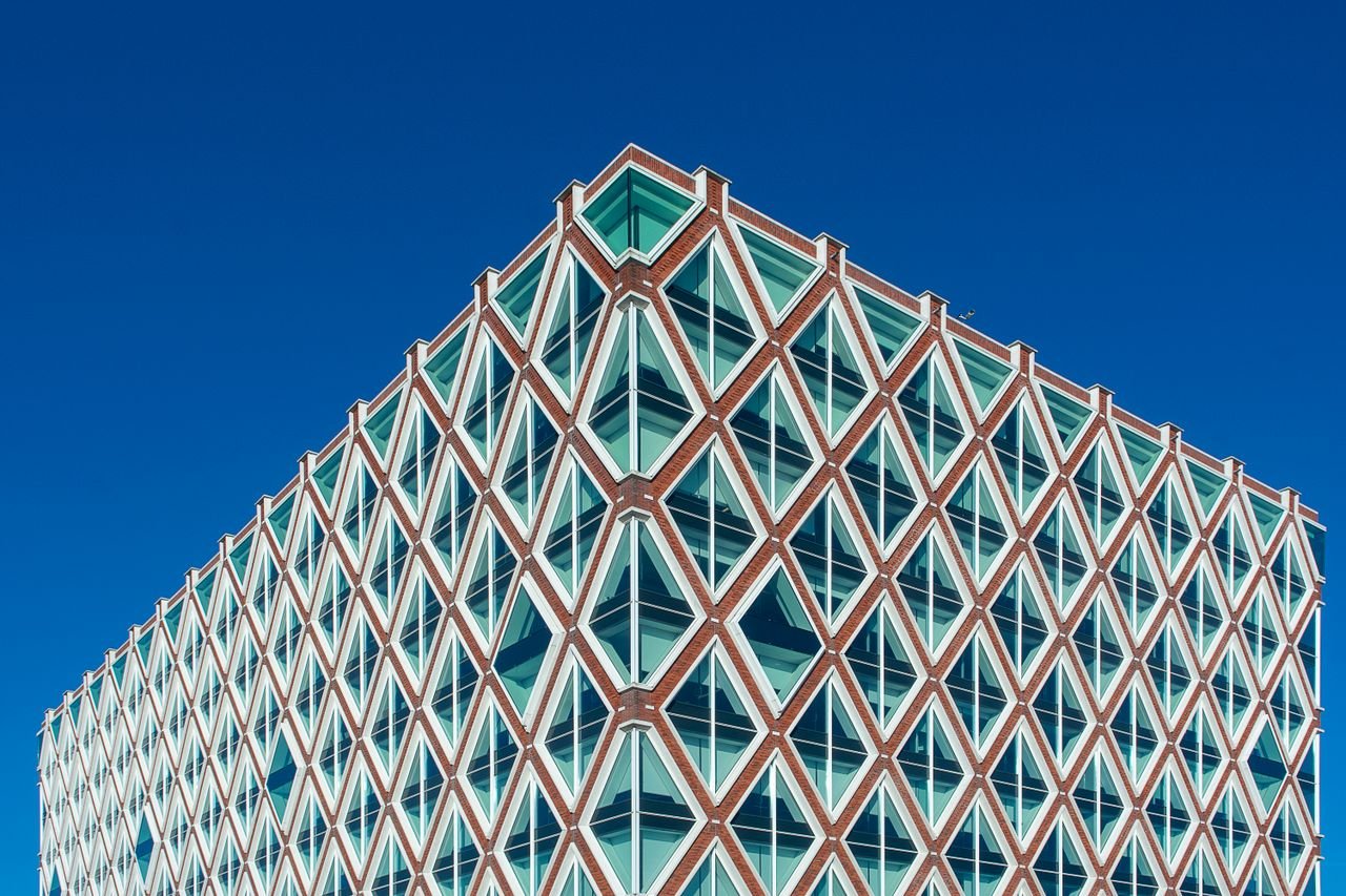 Elegant modern architecture in Gouda, featuring geometric design and vivid blue sky.